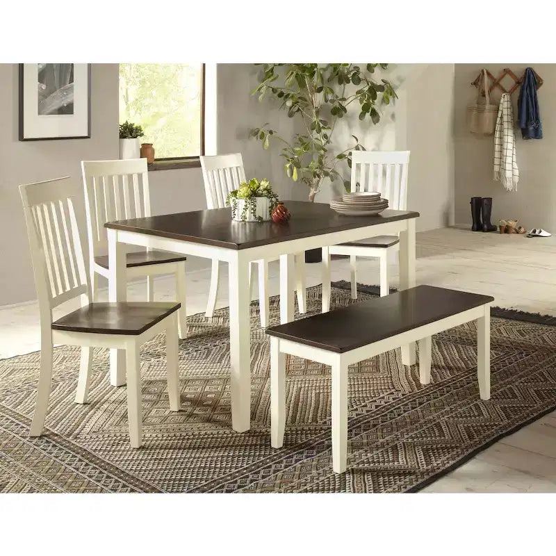 Dining room set with table, chairs, and bench on a patterned rug.