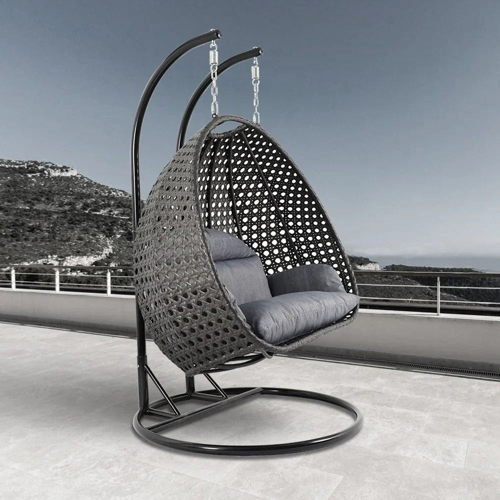 LeisureMod Hängesessel in Ei-Form für 2 Personen mit Gestell - Rattan-Pendelsessel für drinnen und draußen, Hängemattensessel für die Terrasse mit Kissen