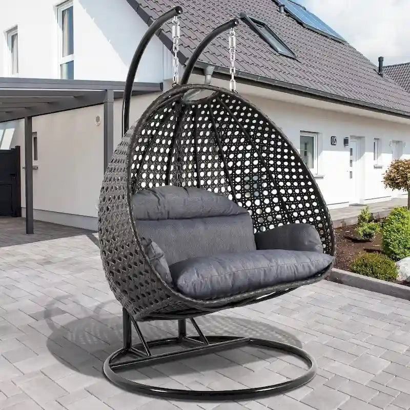 LeisureMod Hängesessel in Ei-Form für 2 Personen mit Gestell - Rattan-Pendelsessel für drinnen und draußen, Hängemattensessel für die Terrasse mit Kissen